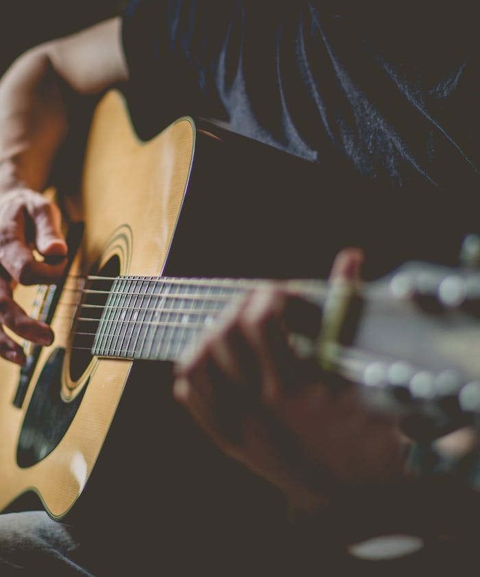 Musician playing acoustic guitar in a studio setting